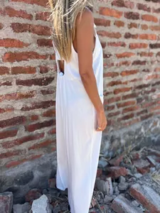 Detail of white loose sleeveless jumpsuit featuring a back cutout and side pockets.