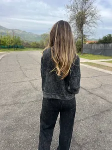 Back view of a women's vintage acid wash black long sleeve and pants two-piece set
