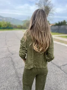 Back view of women's olive green mineral wash sweatshirt and jogger set in outdoor scene