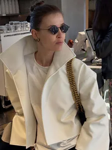 Gros plan d'une veste courte chic en cuir blanc à col montant et manches évasées