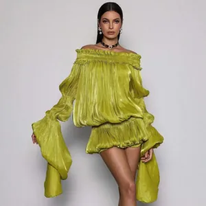 Modelo mostrando un conjunto de top y falda de satén plisado verde lime con hombros caídos