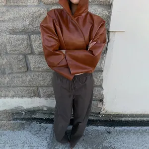 Veste en cuir marron vintage avec col montant et manches larges pour femme.