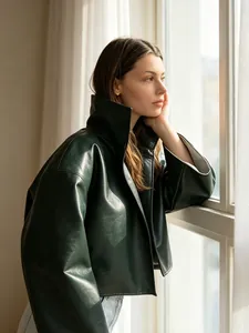 Vue détaillée d'une veste en cuir rétro vert foncé avec col montant et manches évasées