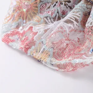 Macro detail of intricate sequin embroidery on mesh fabric for luxury women set