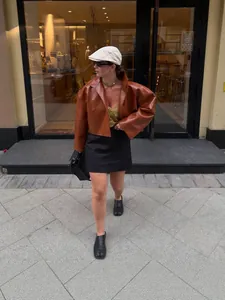 Veste courte vintage en similicuir marron avec manches évasées portées par un mannequin.
