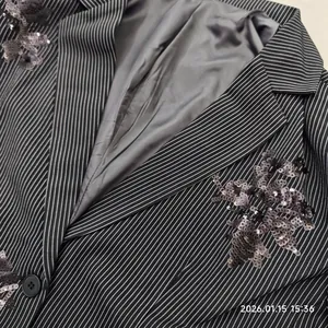 Detail shot of pinstripe suit jacket with sequin floral embroidery and satin lining