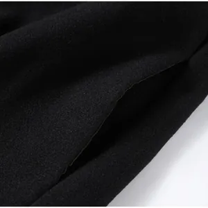 Dettaglio macro della tasca laterale di un cappotto in misto lana nero di alta qualità.
