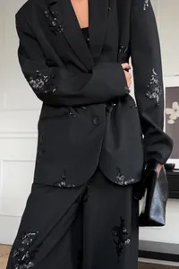 Detailed view of women's pinstripe blazer set with exquisite black sequin embroidery