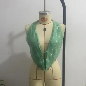 Detalle de un sexy top halter con lentejuelas verdes en un maniquí de exhibición.