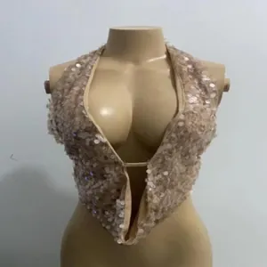 Detalle de un top halter con lentejuelas champán brillantes y escote en V