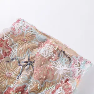Detailed view of intricate floral embroidery and sequins on mesh fabric for a summer outfit