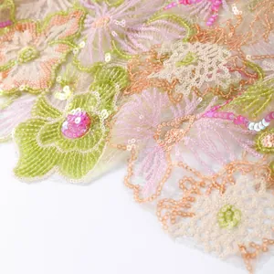 Close-up detail of heavy floral embroidery and shimmering sequins on luxury summer fabric