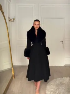 Manteau en laine noir élégant avec col et poignets en fourrure amovibles, style cintré.