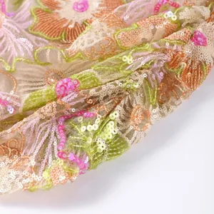Close-up detail showing heavy sequin embroidery and floral patterns on mesh fabric.