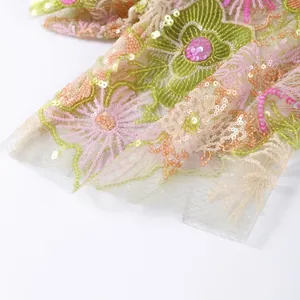 Detailed view of floral embroidery and sequins on delicate mesh fabric garment