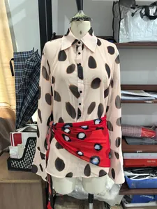 Full detail view of long-sleeved polka dot shirt dress with stylish red waist scarf