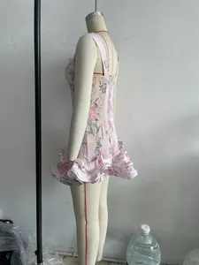 Side view of a pink floral bodycon mini dress with ruffled hem and shirred fabric.