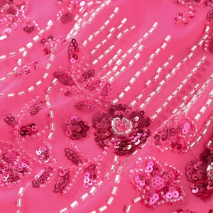 Detailaufnahme der fuchsiafarbenen Paillettenstickerei und Silberperlen auf Netzstoff