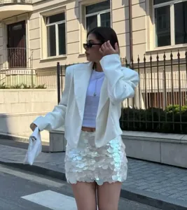 Streetstyle-Look mit einem weißen mehrlagigen Pailletten-Minirock und weißem Blazer