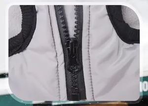 Close-up macro shot of a durable black plastic zipper on a gray waterproof dog winter vest