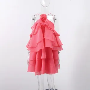 Detail view of the elegant pink ruffled layers and 3D flower on a summer halter dress