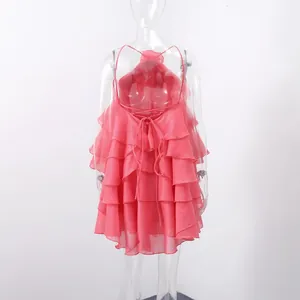 Back view of pink tiered ruffle halter dress with lace-up detail and open back