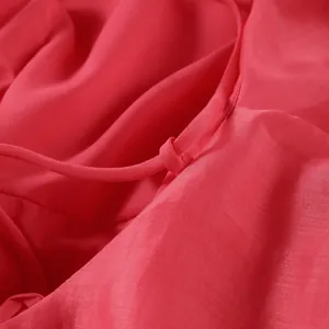 Detailed macro view of textured red fabric and strap construction on backless summer dress