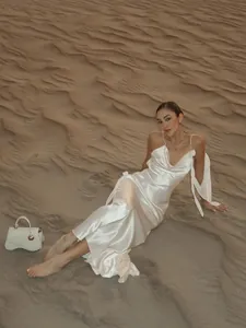 Elegantes weißes rückenfreies Satin-Maxikleid bei einem malerischen Wüsten-Shooting