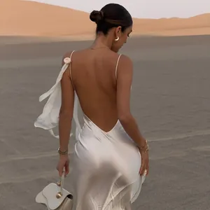 Rückansicht eines sexy weißen Satin-Maxikleids mit freiem Rücken in einer Wüstenumgebung