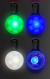 Primer plano de cuatro luces LED de seguridad para mascotas en verde, azul y blanco.