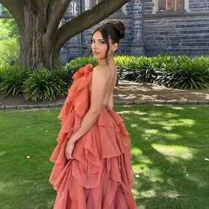 Detailed side profile of an orange tiered ruffle backless maxi dress for resort wear
