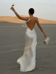 Elegante Rückansicht eines weißen rückenfreien Satin-Maxikleides in einer Wüstenlandschaft
