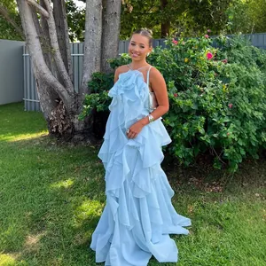 Close-up detail of light blue halter neck maxi dress with 3D flower and elegant ruffled tiers