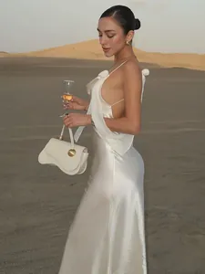 Elegantes rückenfreies weißes Satinkleid für Damen in einer weiten Wüstenlandschaft