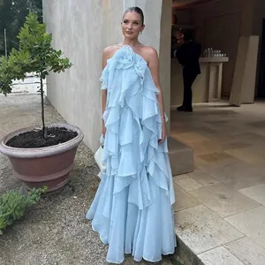 Detailed view of a light blue halter maxi dress with 3D flower and ruffled layers