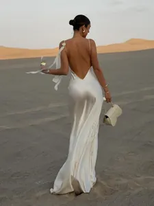 Elegantes weißes rückenfreies Seiden-Maxikleid in malerischer Wüstenlandschaft Detail