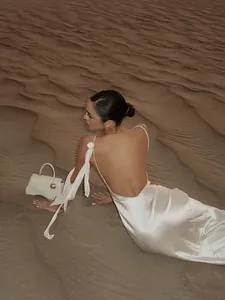 Detailansicht eines eleganten weißen rückenfreien Satin-Kleids in einer Wüstenlandschaft
