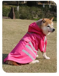 Chubasquero rosa para perro con tiras reflectantes y capucha, llevado por un Shiba Inu al aire libre.