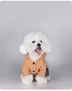 Détail d'un chien blanc portant un manteau d'hiver orange à capuche en flanelle douce.