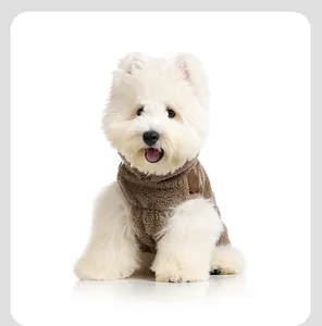 Gros plan d'un chiot blanc portant une veste chaude et douillette en laine d'agneau marron