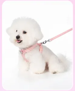 Detailed view of pink dog harness with decorative metal bowknot on a small white dog