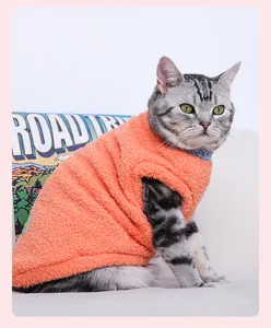 Gros plan sur le gilet en polaire orange pour chat montrant la texture chaude.