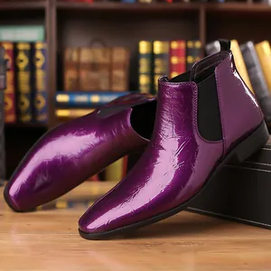Detalle de botas Chelsea de charol morado con textura brillante y punta afilada.