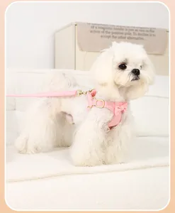 Detailed view of pink suede pet harness with a bow on a white dog