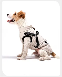 Zijaanzicht van een hond in een beige waterdicht warm wintervest met een hondentuigje