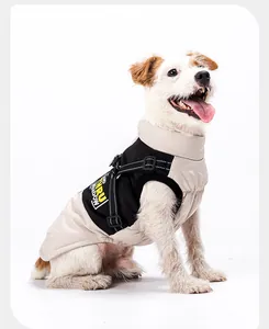 Zijaanzicht van hond in een beige en zwarte waterdichte winterjas met harnasgordel