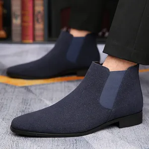 Vista detallada de botas Chelsea azul marino con un diseño elegante de punta fina.
