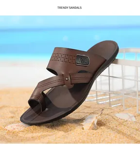 Detailansicht brauner Herren-Strandsandalen mit weicher rutschfester Sohle auf Sandstrand