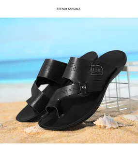 Professionelle Detailaufnahme schwarzer Herren-Sandalen aus Leder am Sandstrand.