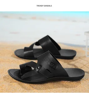 Bequeme schwarze Herren-Freizeitsandalen mit Zehenschlaufe vor dem Strandhintergrund